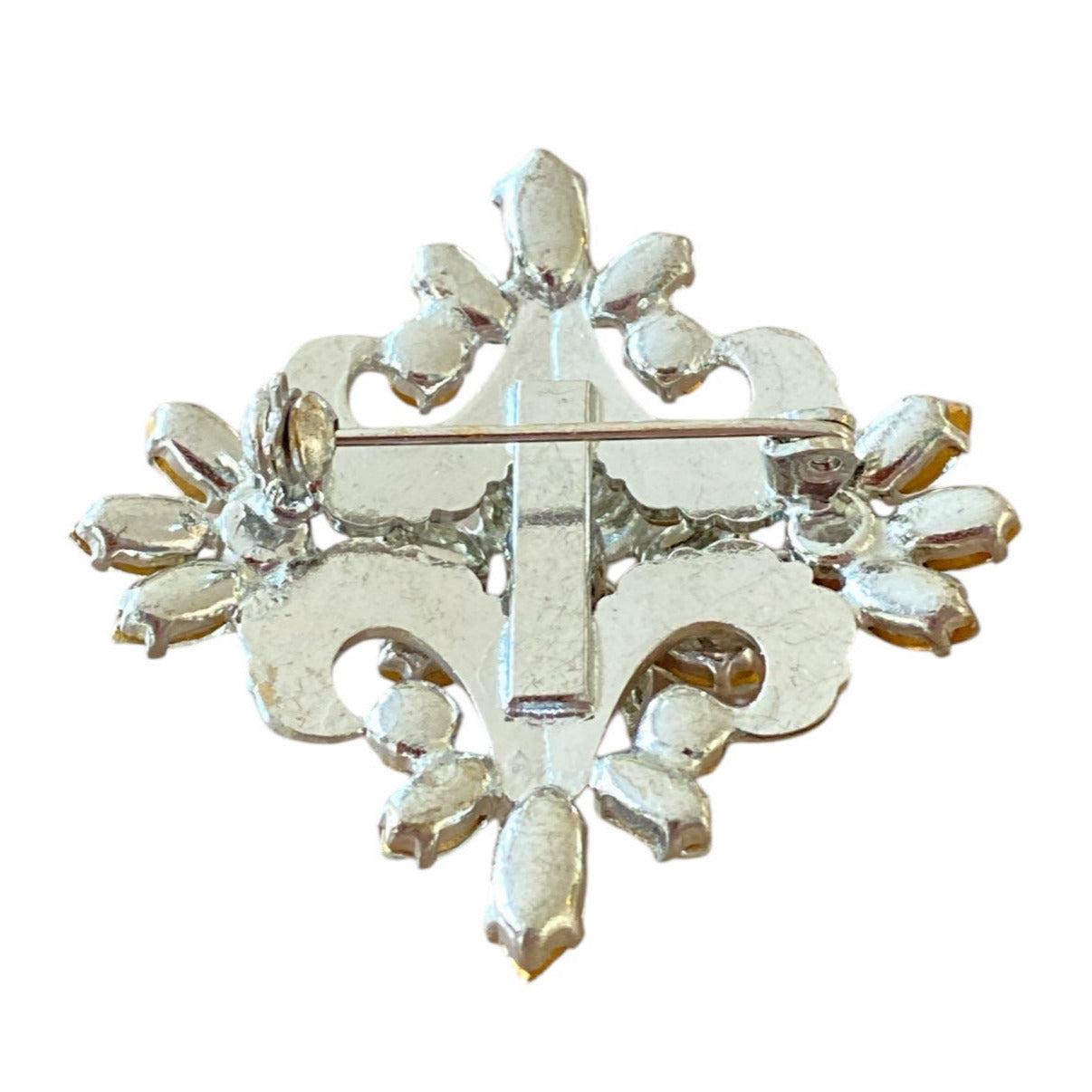 Brosje i sølvfarget metall med fasettslipte blå og blanke stener