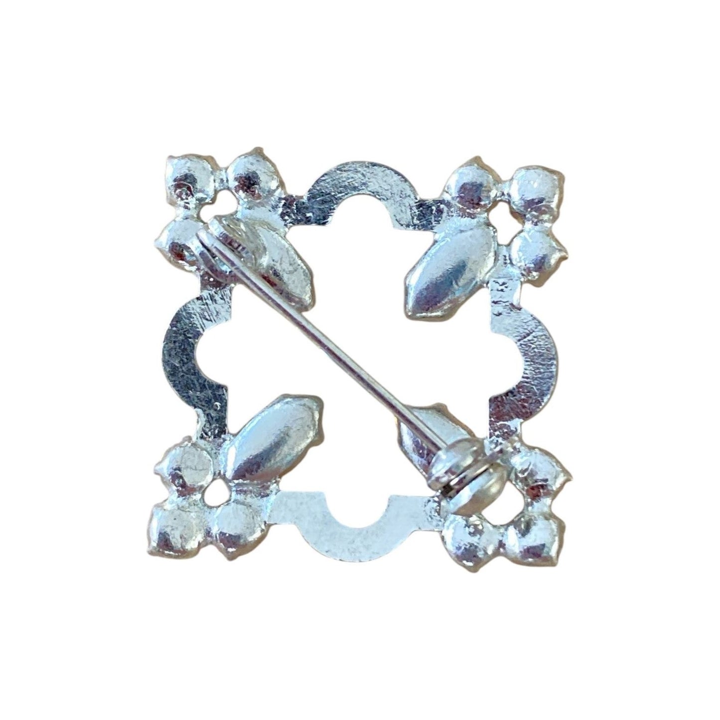 Brosje i hvitt metall med fargede og blanke stener. (Grønn)