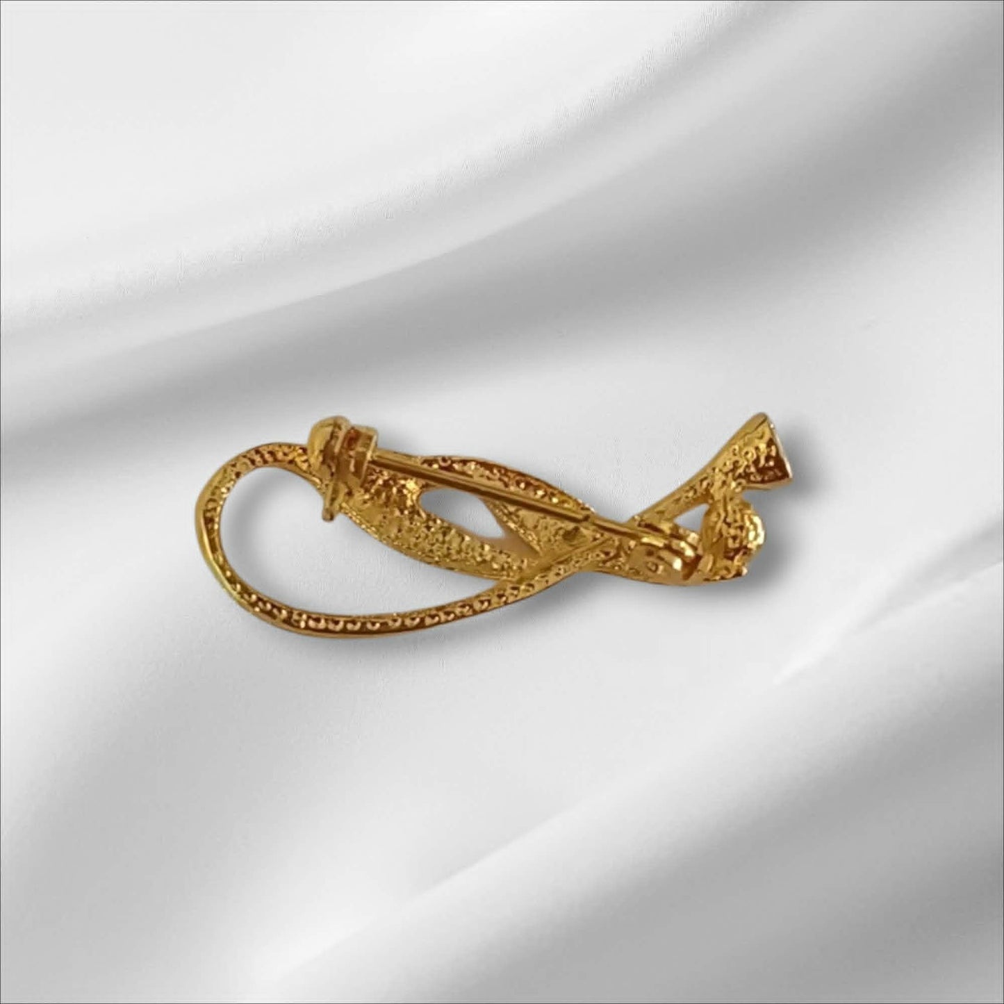 Gullfarget brosje med sten, i elegant swirldesign