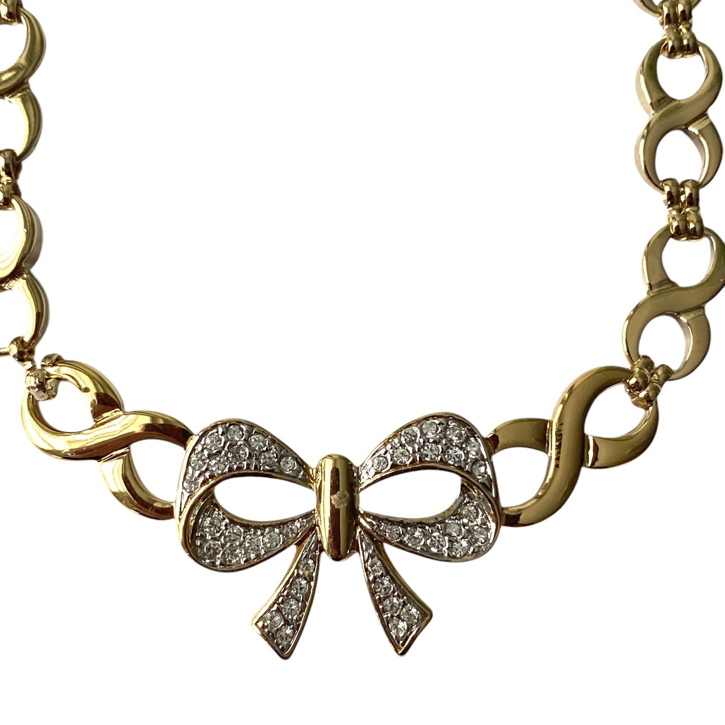 Gullfarget kjede med sløyfe og blanke stener