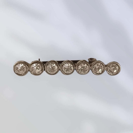 Vintagebrosje med hvite krystaller i rekke