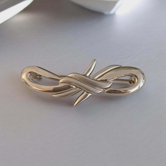 Sølvfarget vintagebrosje med elegant knutedesign