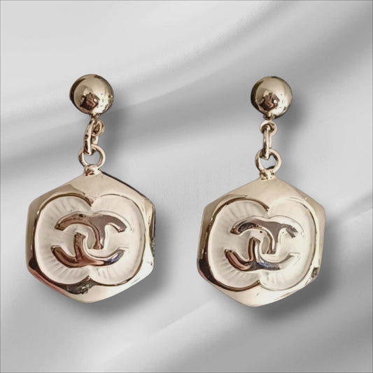 Sølvfargede øredobber med dekorative relieff-former