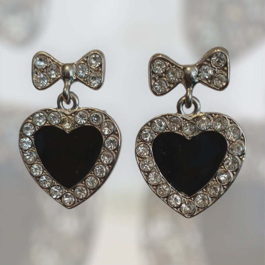 Krystallinnrammede øredobber med sort hjerte og sløyfedetalj