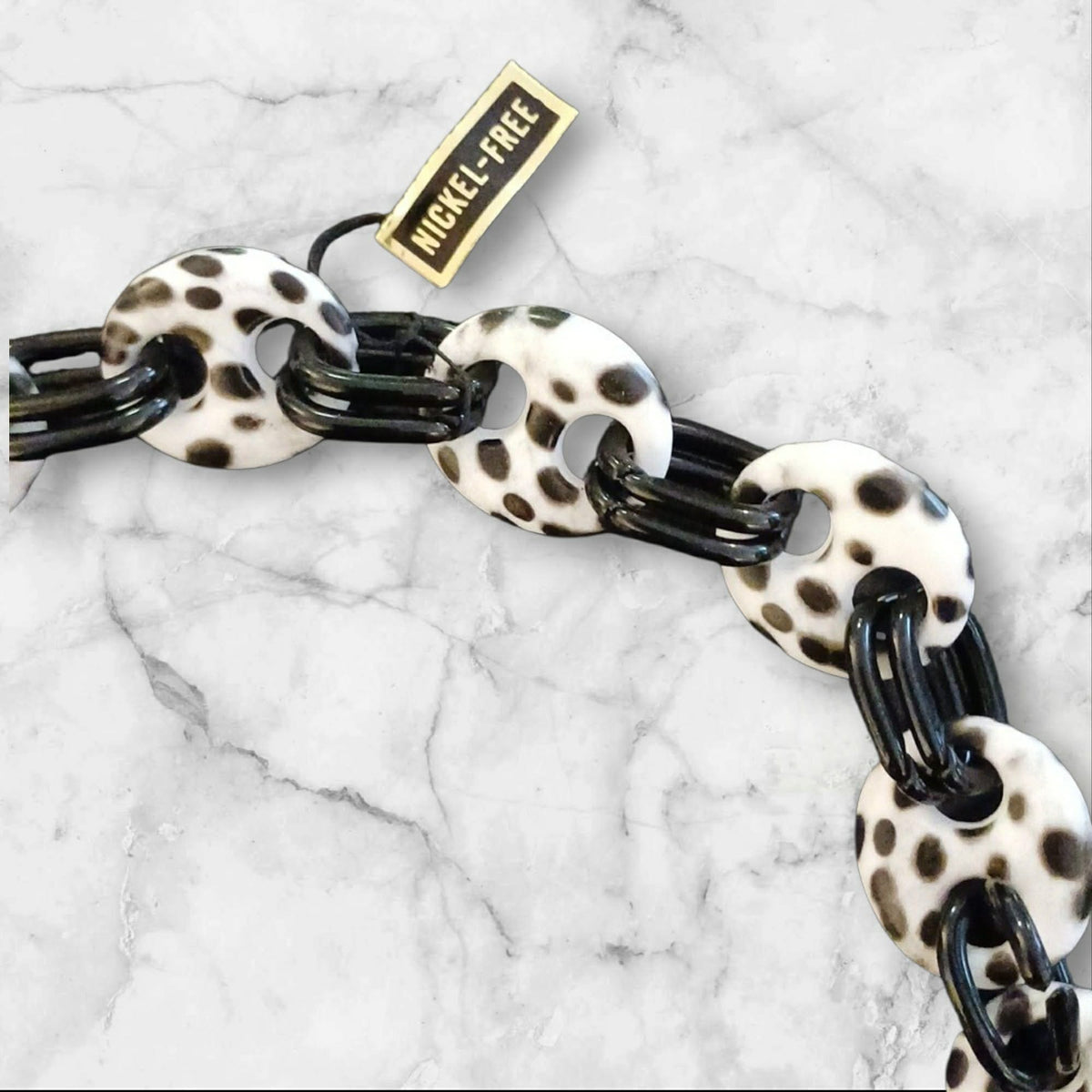 Langt kjede med hvite leopardmønstrede ledd