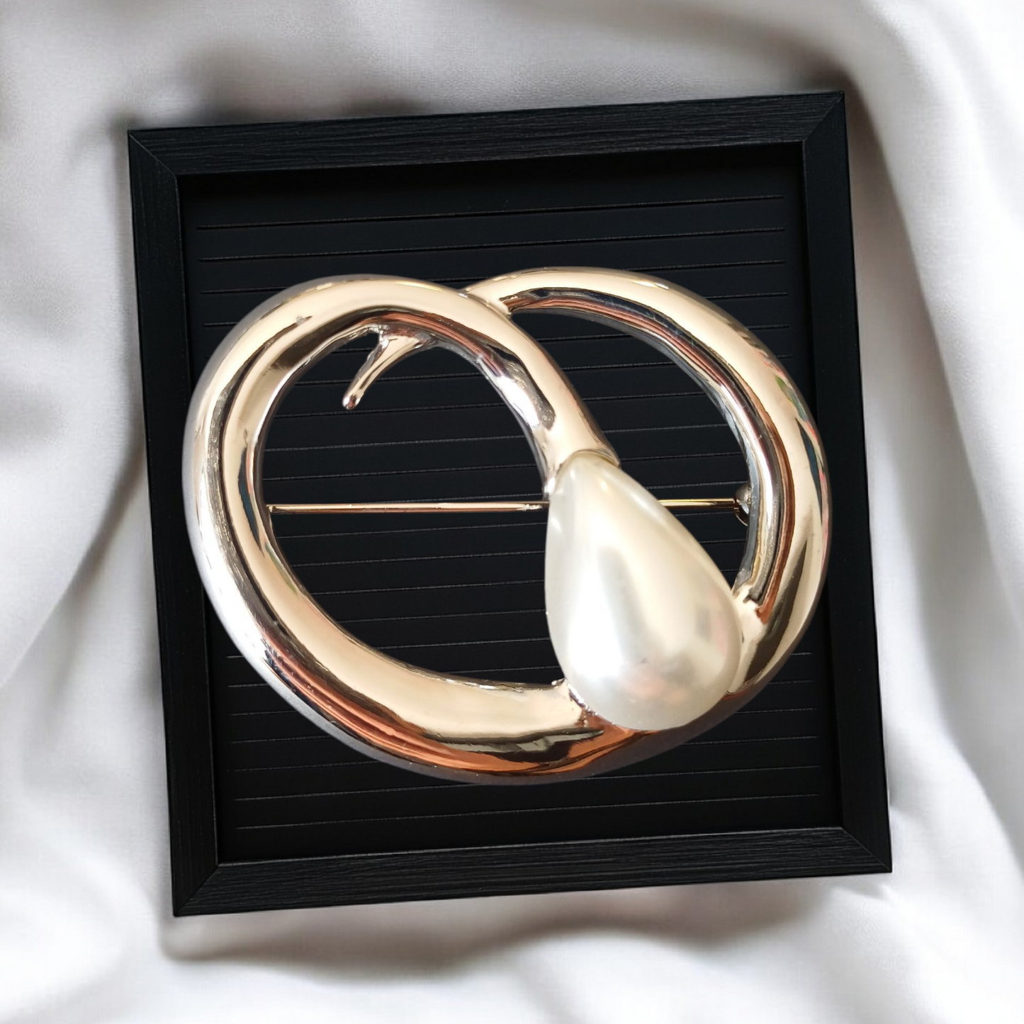 Stor sølvfarget brosje med dråpeformet perledetalj