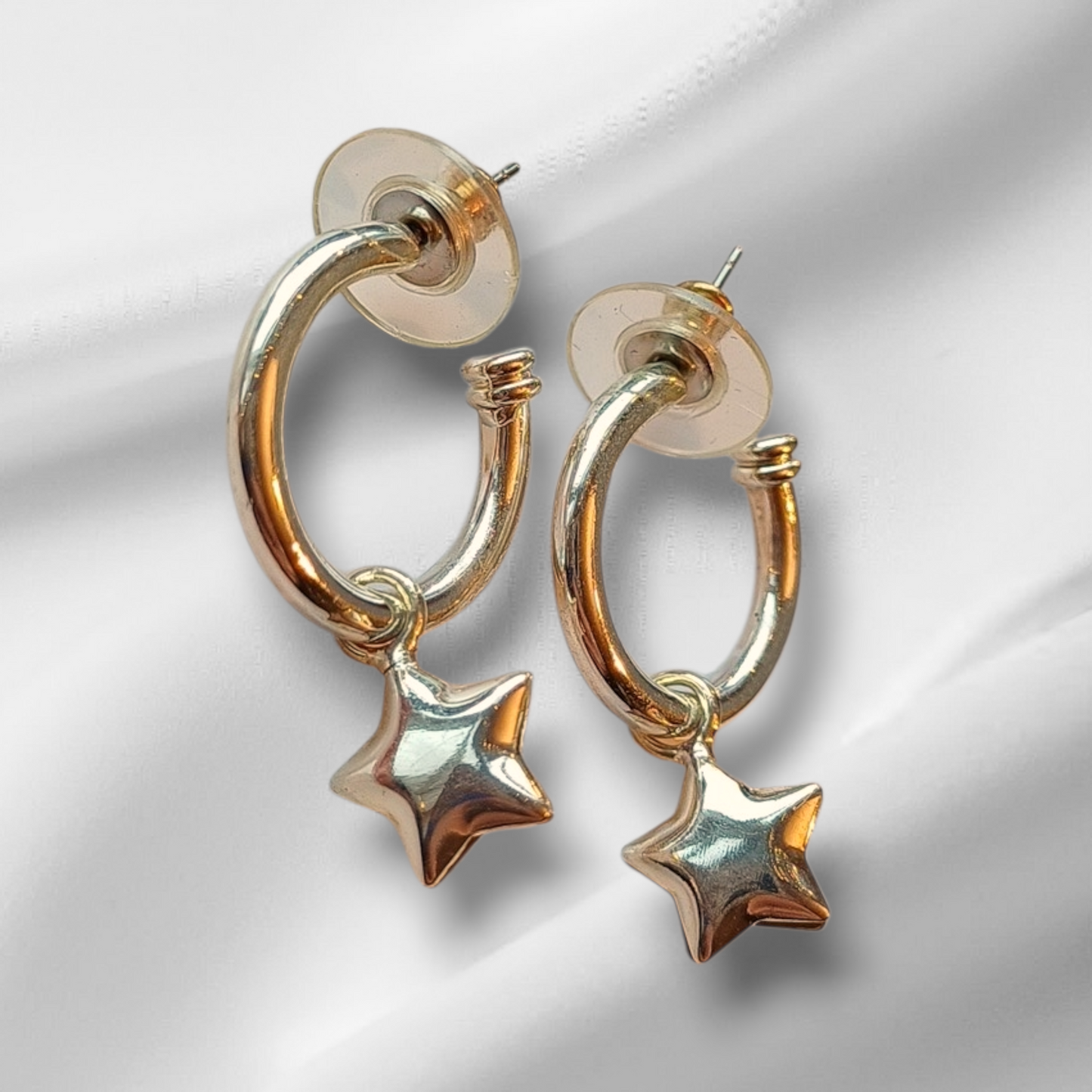 Øredobber i gullfarget metall med stjerneanheng