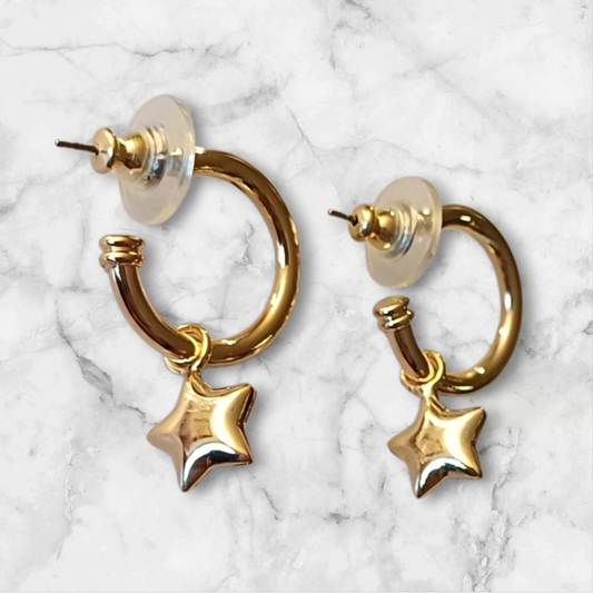 Øredobber i gullfarget metall med stjerneanheng